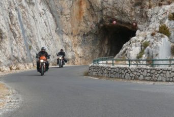 zwei Motorradfahrer fahren aus einem Tunnel