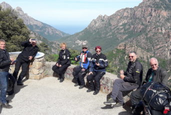 Korsika-Gruppe-pausiert-auf-einer-Mauer