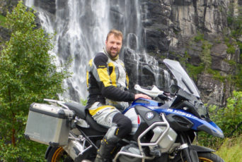 Norwegen-Motorradfahrer-vor-Wasserfall